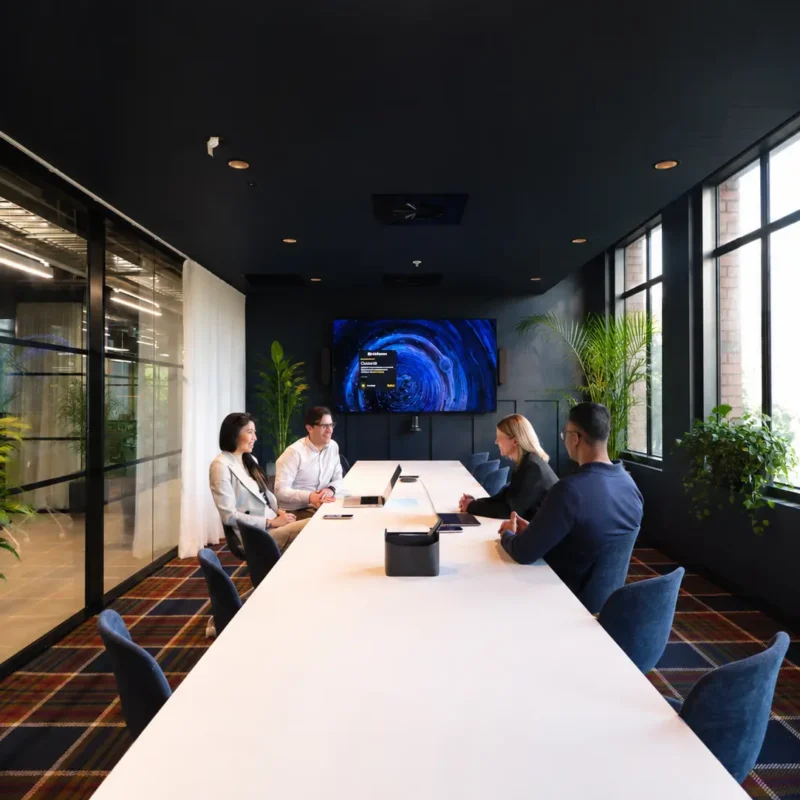 Small professional team using a technology-equipped meeting room within CreativeCubes.Co serviced private offices